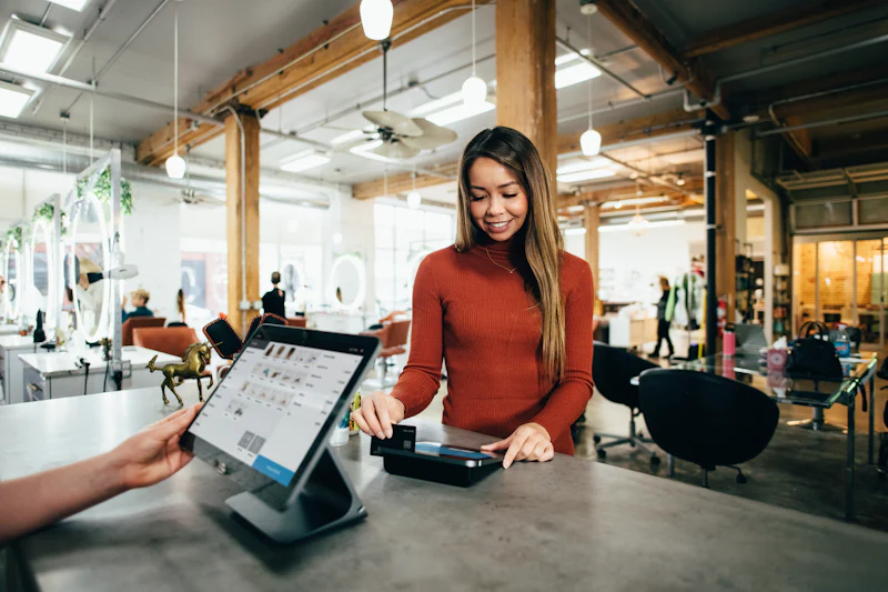 Local shop owner helping a customer at a tablet point-of-sale counter