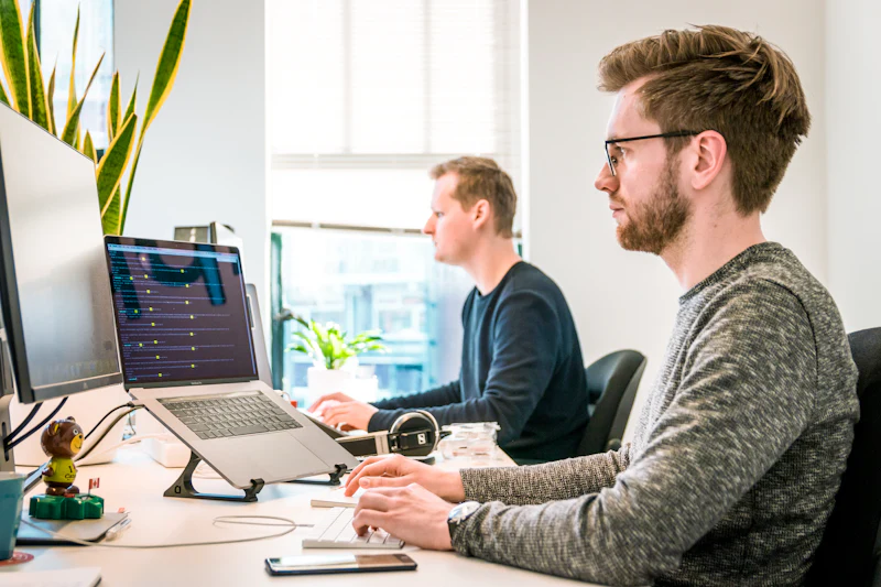 Team members working at computer monitors in a bright office